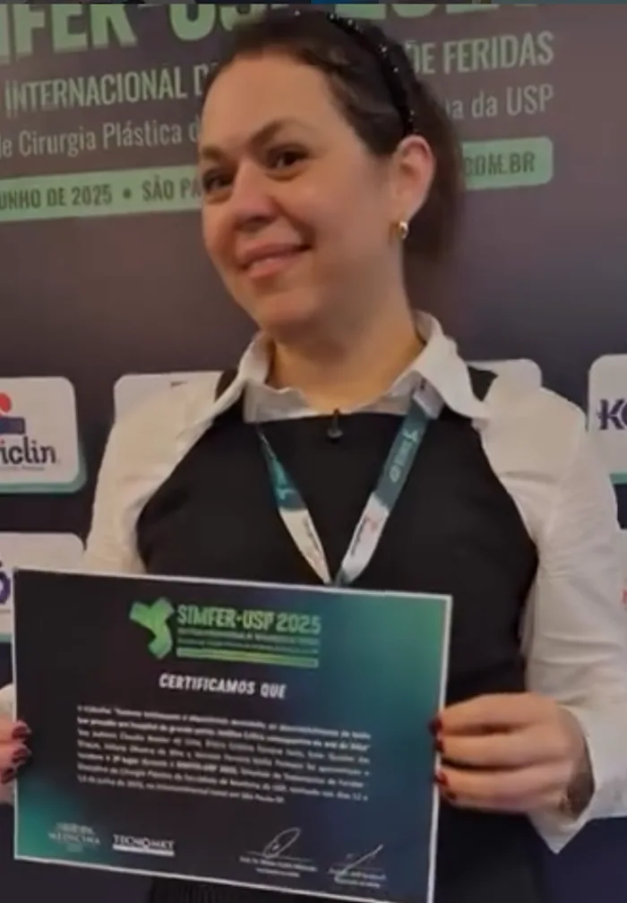 Elaine Ianni recebendo o certificado de 2º lugar no SIMFER-USP 2025, simpósio internacional de feridas da USP